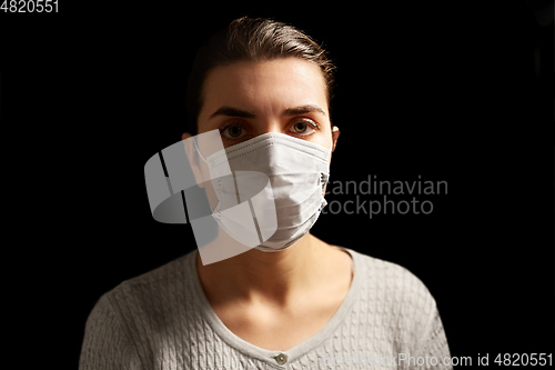 Image of sick young woman in protective medical face mask