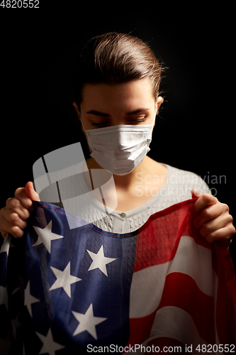 Image of sick woman in face mask holding flag of america