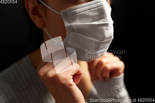 Image of sick woman adjusting protective medical face mask