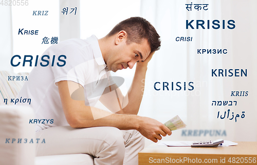 Image of stressed man with money and calculator at home