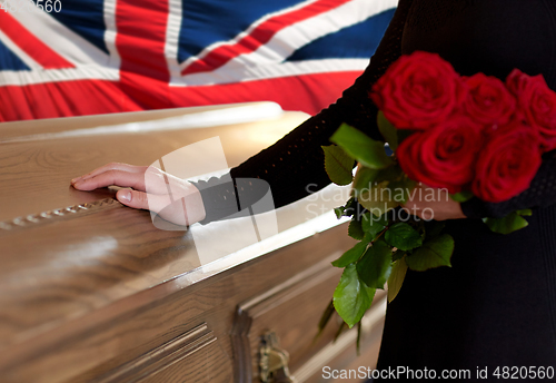 Image of woman with red roses and coffin over english flag