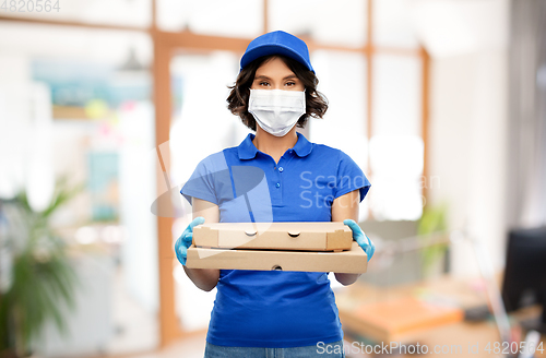 Image of delivery woman in mask with pizza boxes at office