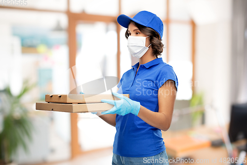 Image of delivery woman in mask with pizza boxes at office