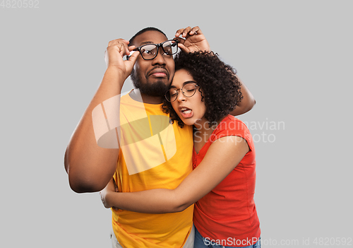 Image of happy african american couple in glasses hugging