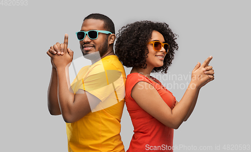 Image of african couple in sunglasses making gun gesture