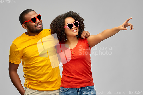 Image of happy african couple in heart shaped sunglasses
