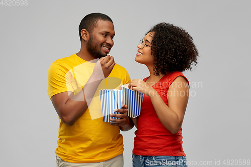 Image of happy african american couple eating popcorn