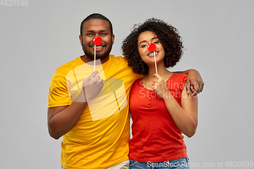 Image of happy african american couple with red clawn noses