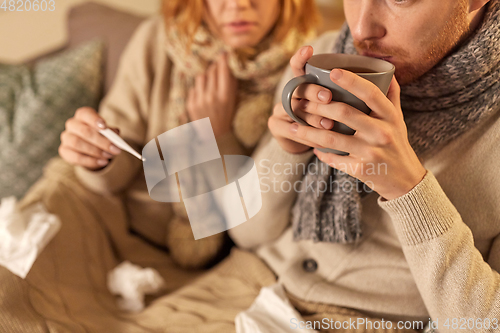 Image of close up of sick young couple drinking tea at home