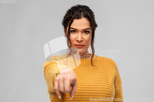 Image of young woman pointing finger to camera