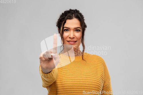 Image of happy woman in pullover showing one finger