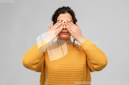 Image of woman with eyes closed by hands