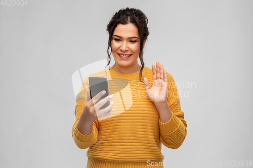 Image of happy young woman having video call on smartphone