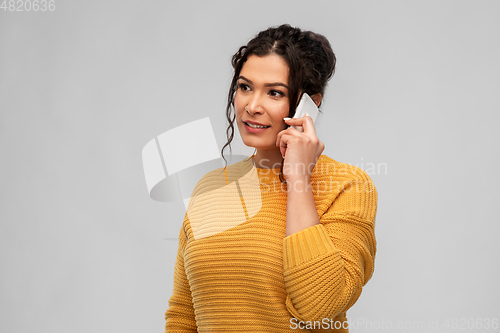 Image of happy young woman calling on smartphone