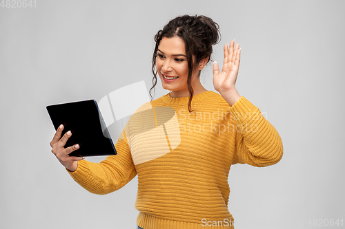 Image of happy young woman having video call on tablet pc