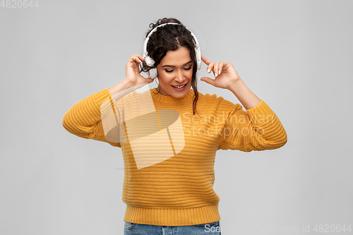 Image of happy woman in headphones listening to music