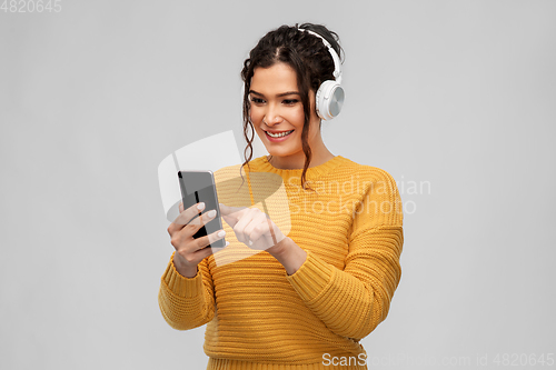 Image of woman in headphones with smartphone