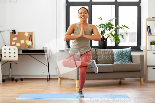 Image of african american woman doing yoga pose at home