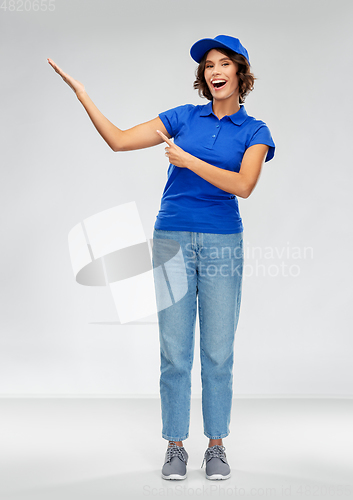 Image of happy smiling delivery woman in blue uniform