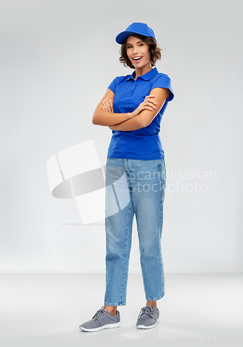 Image of happy smiling delivery woman in blue uniform