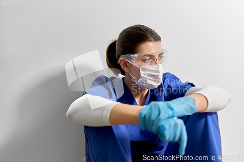 Image of sad doctor or nurse in goggles and face mask