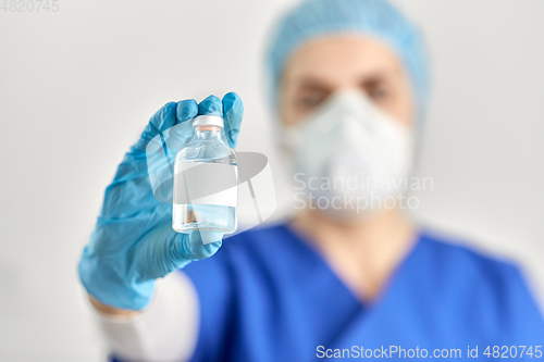 Image of close up of doctor's hand with bottle of medicine