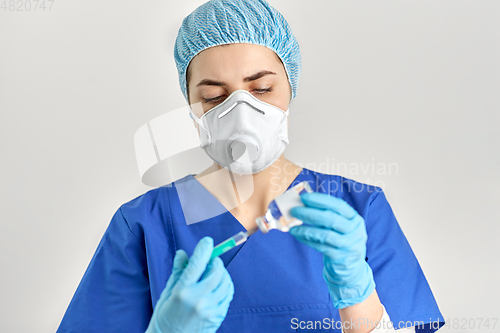 Image of doctor in face mask with syringe and medicine