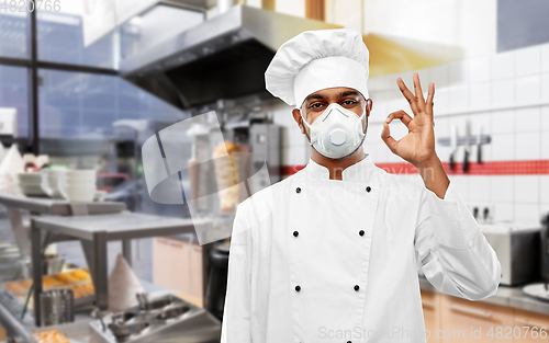 Image of chef in respirator showing ok sign at kitchen