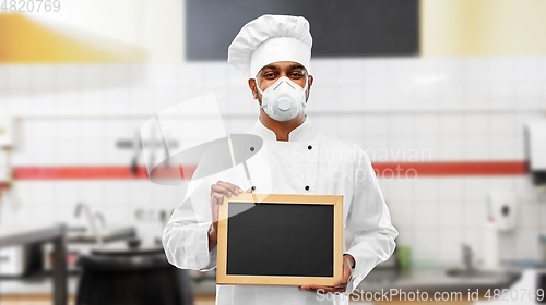 Image of chef in respirator with chalkboard at kitchen