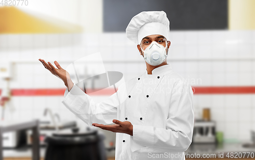 Image of male chef in respirator at restaurant kitchen