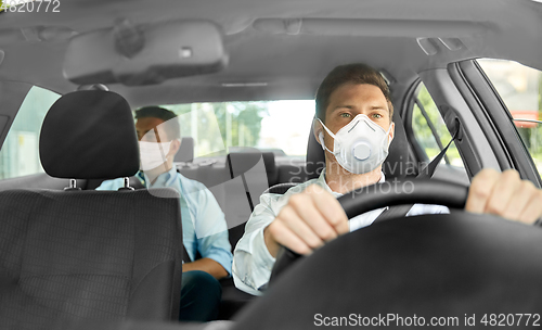 Image of taxi driver in mask driving car with passenger