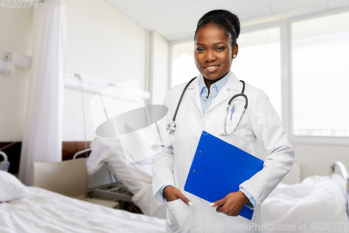 Image of happy african doctor with clipboard at hospital