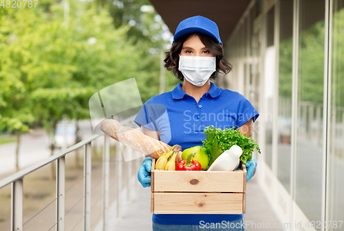 Image of delivery woman in mask with food in box outdoors