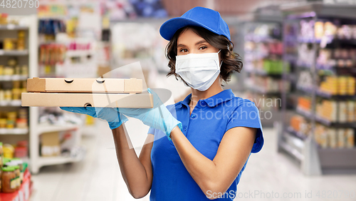 Image of delivery woman in mask with pizza boxes at store