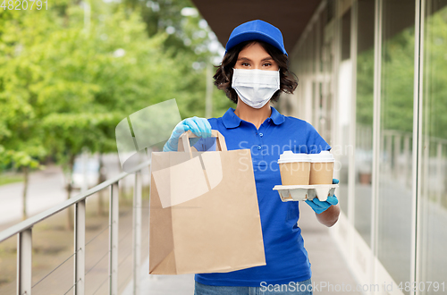 Image of delivery girl in mask with food and drinks in city