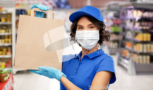 Image of delivery woman in mask with food in bag at store