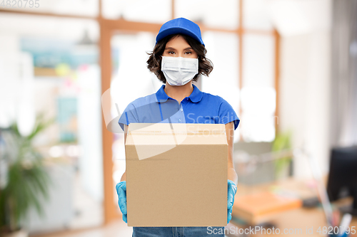 Image of delivery woman in mask with parcel box at office