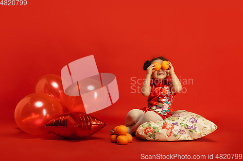 Image of Happy Chinese New Year. Asian little girl portrait isolated on red background