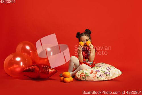 Image of Happy Chinese New Year. Asian little girl portrait isolated on red background