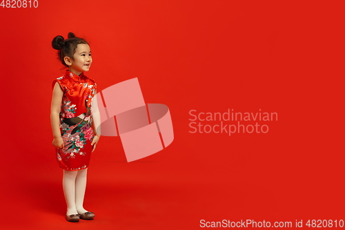 Image of Happy Chinese New Year. Asian little girl portrait isolated on red background