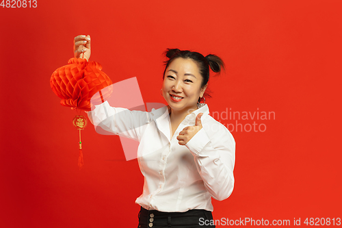 Image of Happy Chinese New Year. Asian young woman portrait isolated on red background