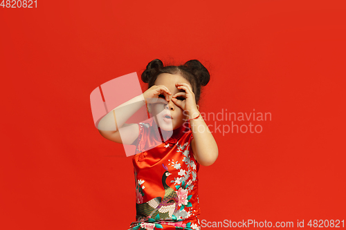 Image of Happy Chinese New Year. Asian little girl portrait isolated on red background