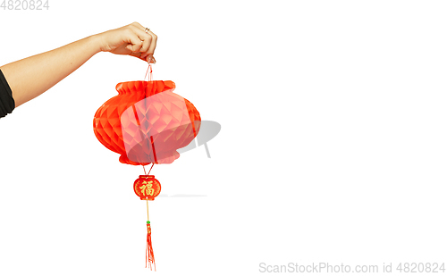 Image of Happy Chinese New Year. Female hand holding lantern on white background