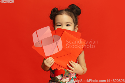 Image of Happy Chinese New Year. Asian little girl portrait isolated on red background