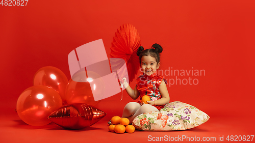 Image of Happy Chinese New Year. Asian little girl portrait isolated on red background