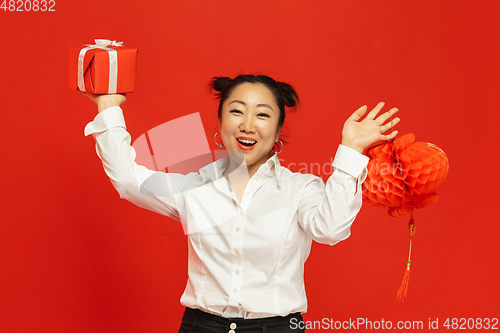 Image of Happy Chinese New Year. Asian young woman portrait isolated on red background