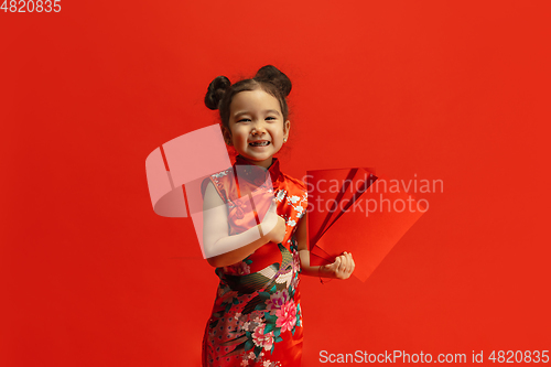 Image of Happy Chinese New Year. Asian little girl portrait isolated on red background