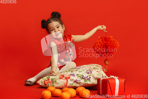 Image of Happy Chinese New Year. Asian little girl portrait isolated on red background