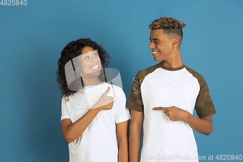 Image of Young emotional african-american man and woman on blue background