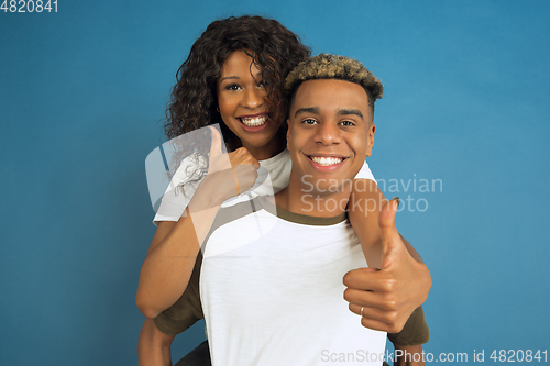Image of Young emotional african-american man and woman on blue background